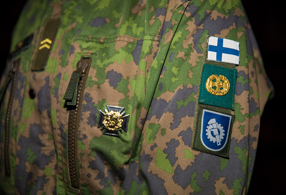 Kuvassa varusmiehen lomatakin tarranauha, jossa on tunnuksia.