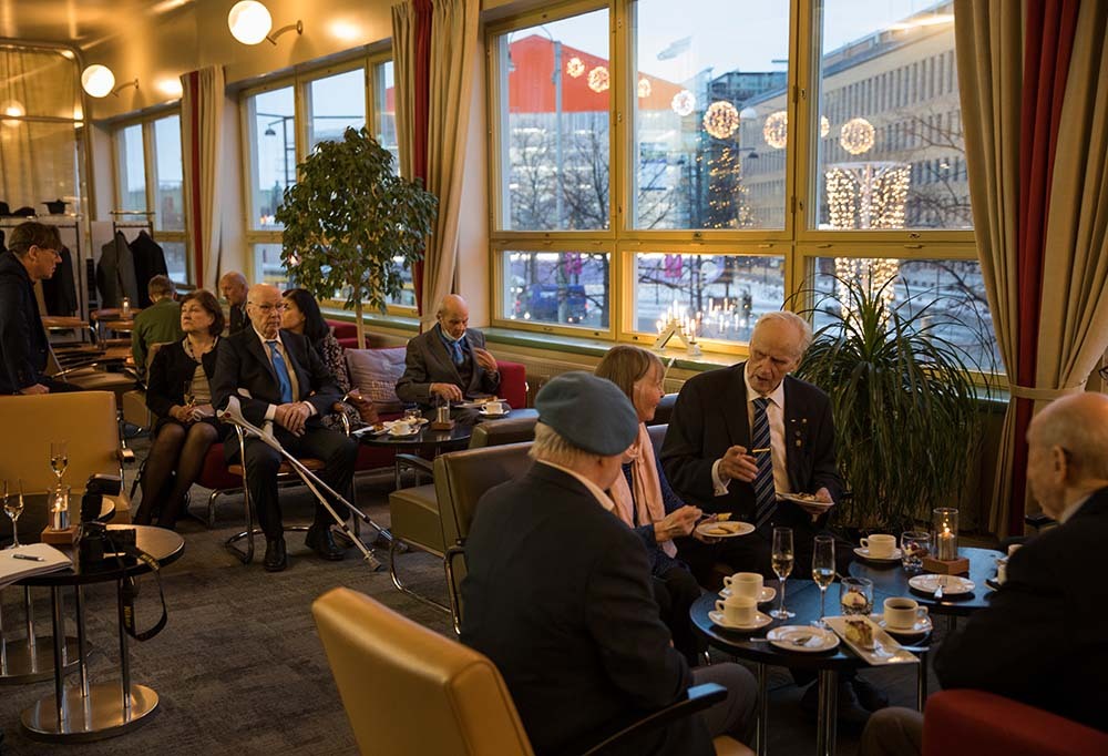 Kuvassa ihmisiä kahvipöydän äärellä Rauhanturvaajaliiton juhlatilaisuudessa