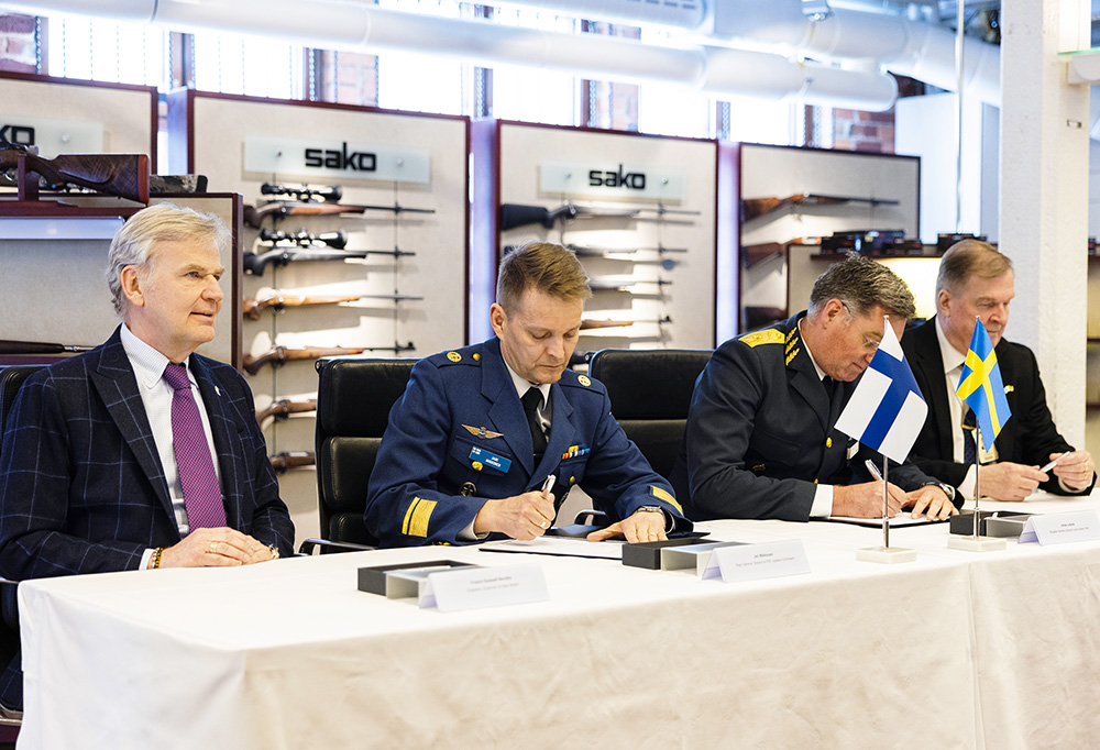 Kuvassa allekirjoitetaan sopimus uusista käsiaseista.