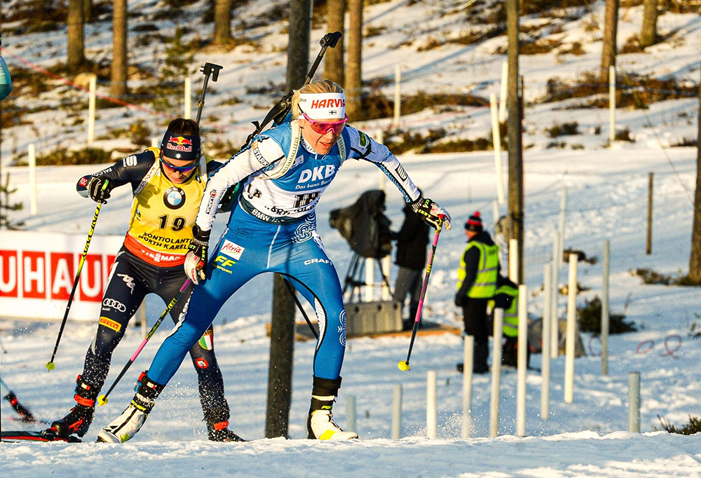 Mäkäräinen hiihtää ylämäkeen kannoillaan toinen hiihtäjä.