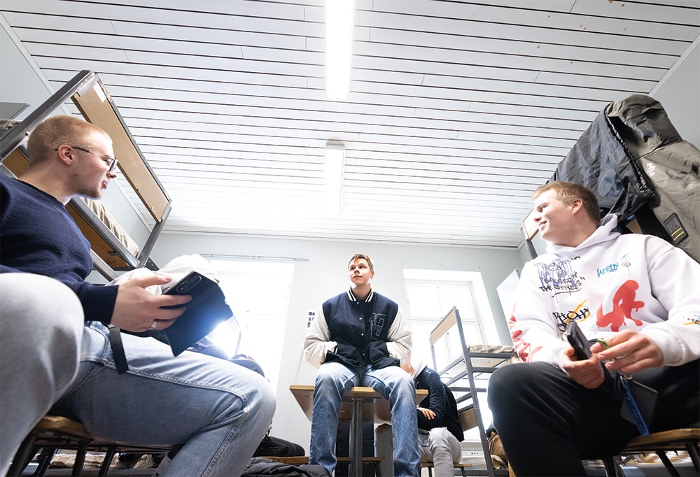 Kolme henkilöä tuvassa odottamassa kotiin lähtemistä