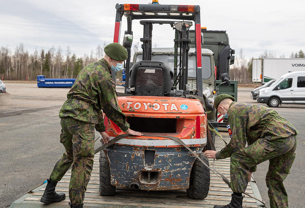 Kaksi varusmiestä kuorman sidontaa testaamassa.