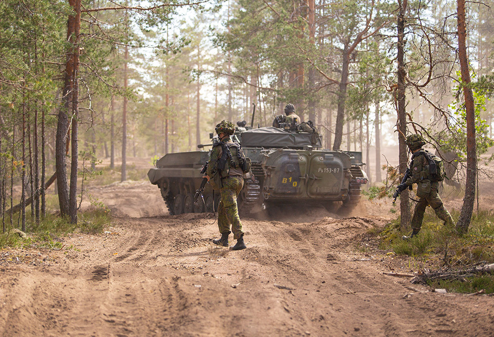 Varusmiehiä ja panssarivaunu.