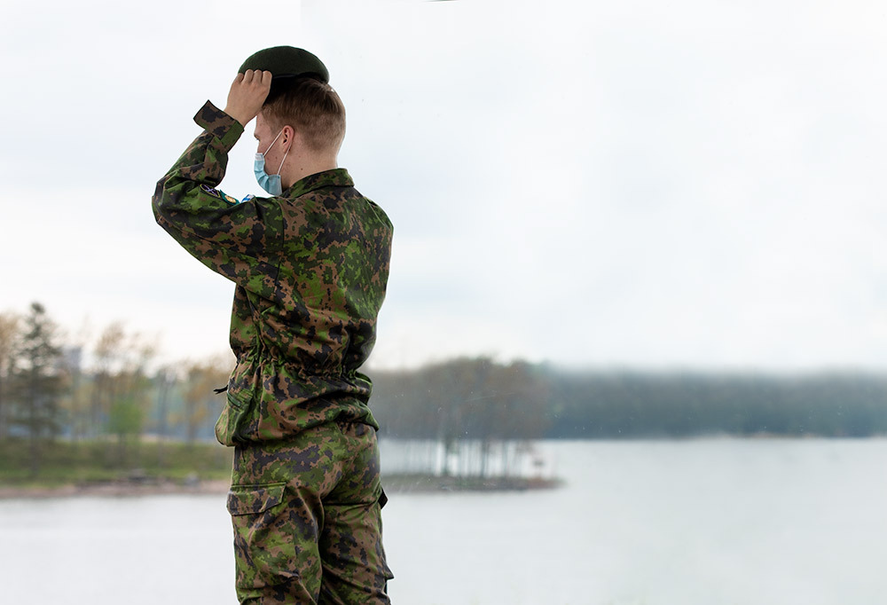 Kuvassa varusmies laittamassa barettia päähän.