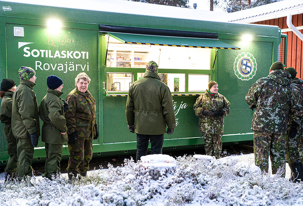 Kuvassa vastavihkityn sotilaskotikontin ympärille kerääntynyt joukko.