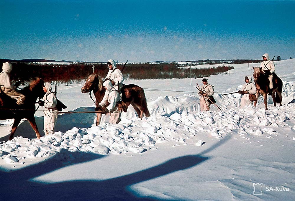 Hämeen Ratsurykmentin miehiä etenemässä ratsain ja hiihtäen talvisissa maisemissa Velikaja Nivassa.