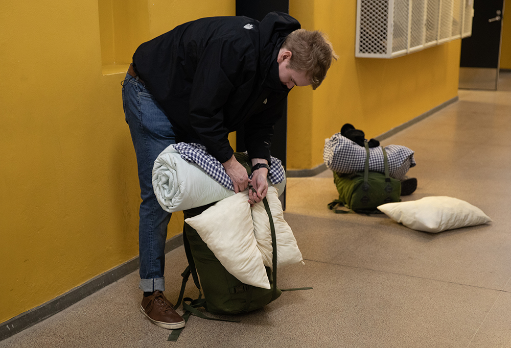 Reserviin siirtyvä varusmies siviilivaatteissa pakkaamassa tavaroitaan.