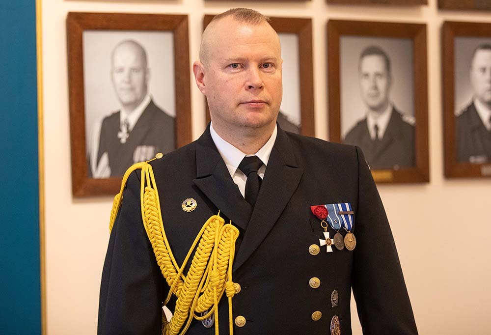 Miespuolinen kommodori seisoo.