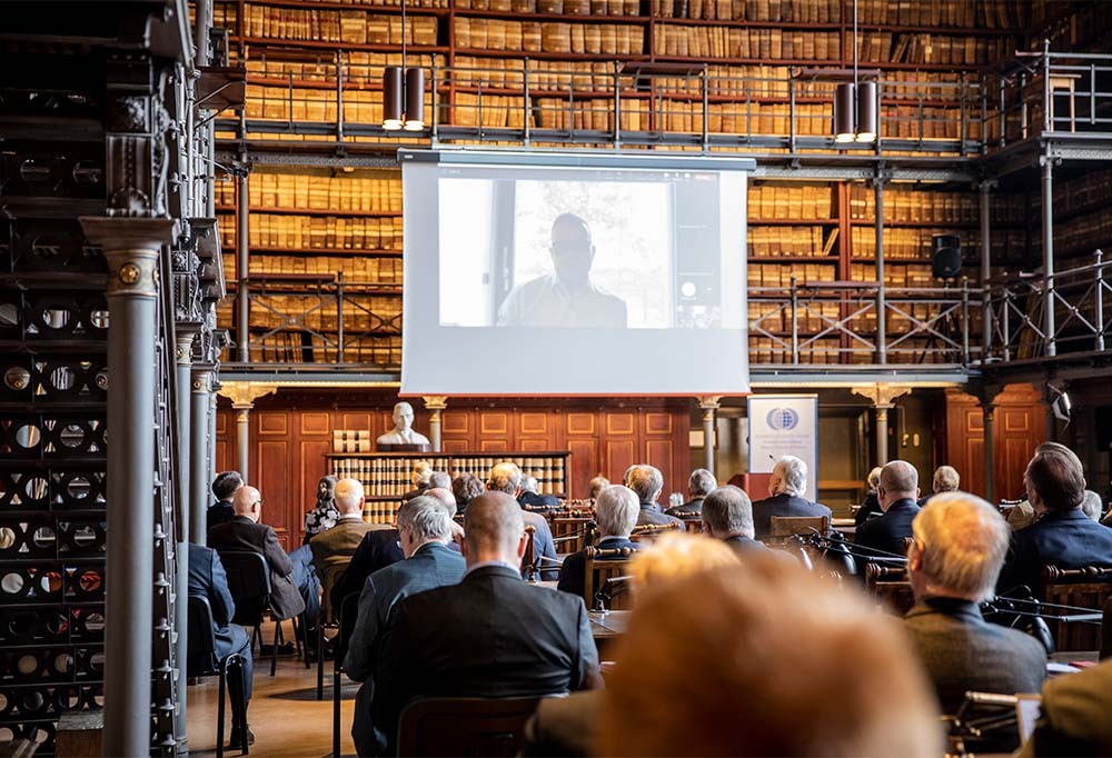 Kuvassa luentosali ja Petteri Orpo valkokankaalla.