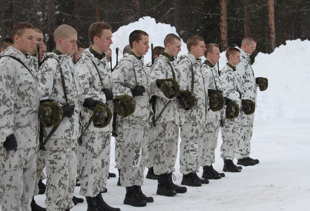 Kuvassa rivi sotilaita lumipuvuissa.
