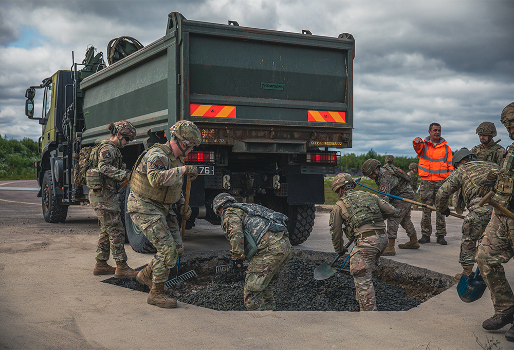Nato-pioneerit täyttävät kuoppaa.
