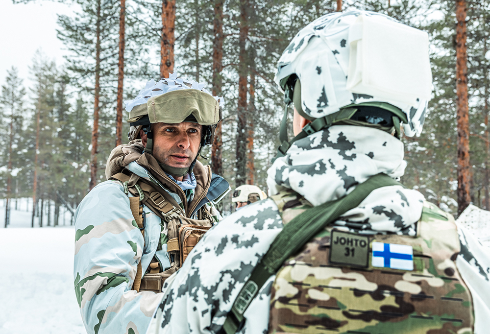 Ranskalainen sotilas kättelee suomalaista sotilasta talviolosuhteissa