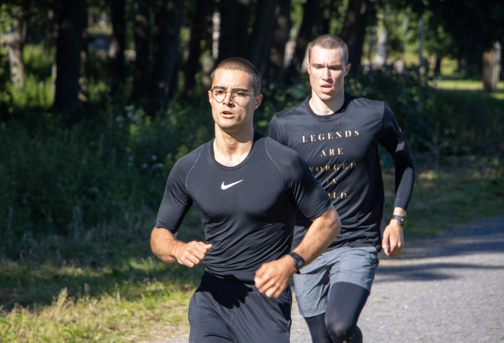 Kuvassa juoksee kaksi nuorta miestä.