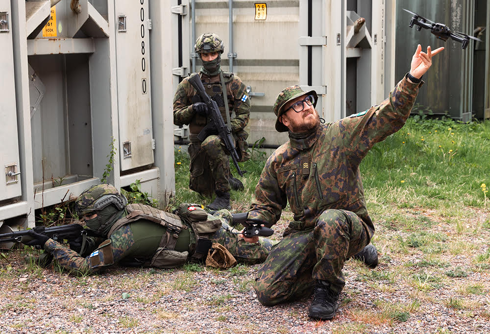 Kuvassa reserviläinen pitää droonia kädessä.