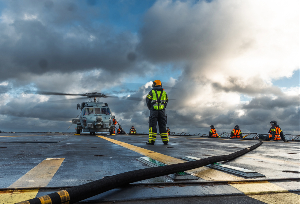 Kurssin johtajat ja kurssilaisia korkeassa polviasennossa metsässä aseiden kanssa.