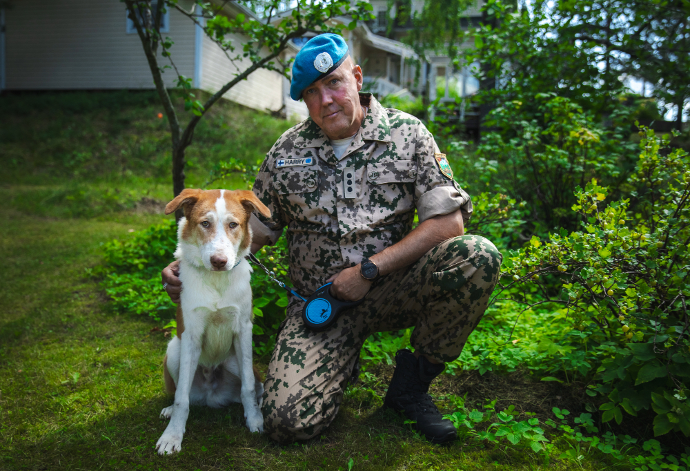 Kapteeni Harry Lagerström poseeraa pitäen hihnassaan Lucky-koiraansa.