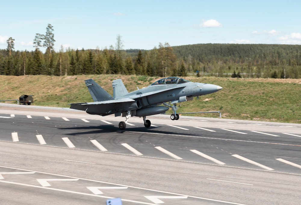 Hornet laskeutumassa varalaskupaikalle. Taustalla mäkistä metsämaastoa.