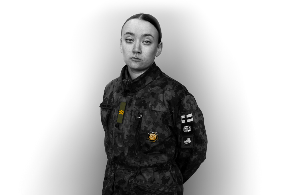 Alikersantti Karoliina Huopalainen seisoo kädet selän takana ja katsoo kohti kameraa.