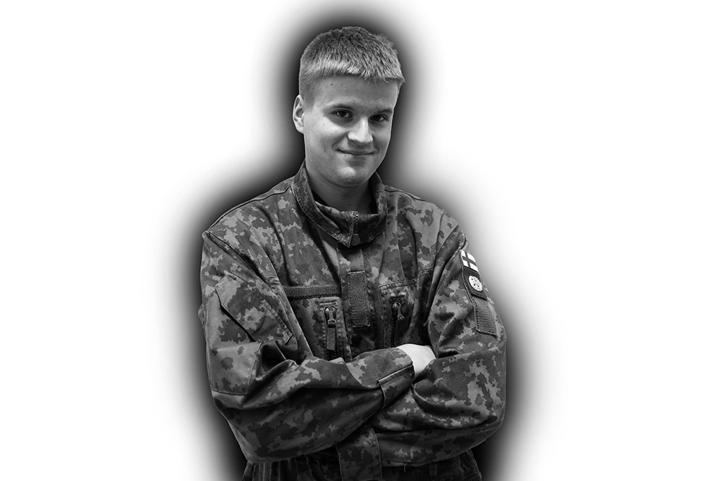 Kaartinjääkäri Hyvärinen seisoo kädet puuskassa ja katsoo kameraa hymyillen.