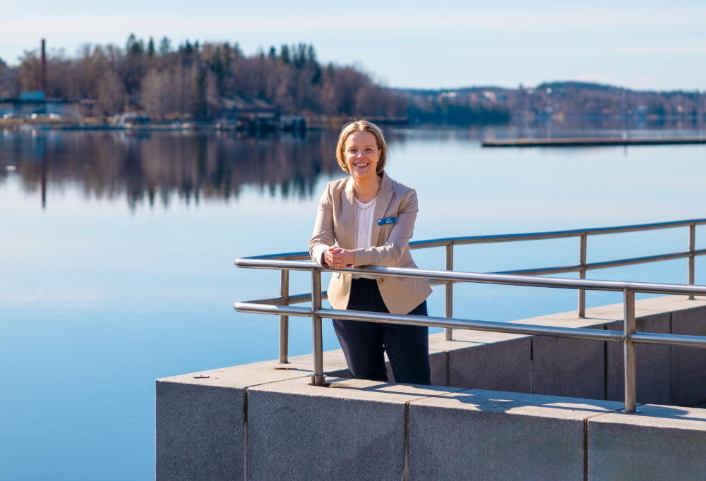 Jokisalo hymyilee kameralle nojaten kaiteeseen. Taustalla saaristoa.