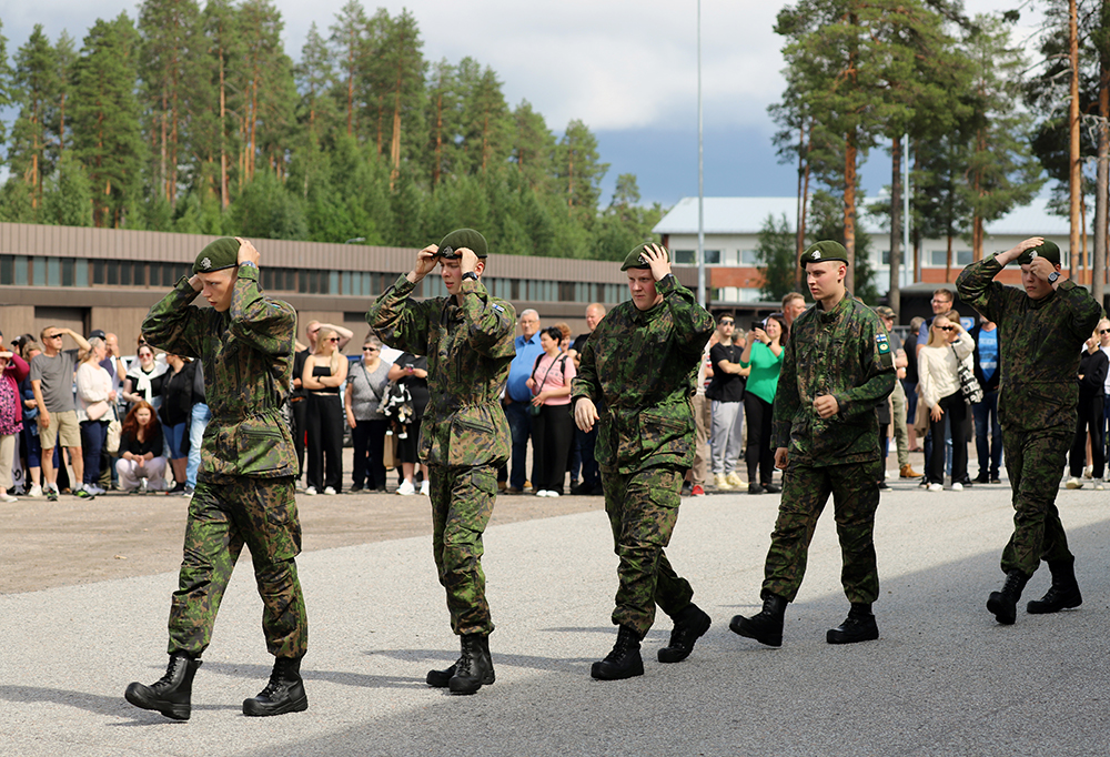 Kuvassa neljä varusmiestä kulkee jonossa