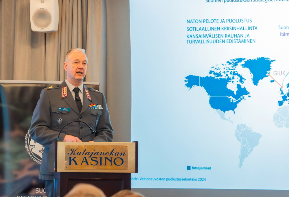 Vasemmalla eversti Petteri Kajanmaa puhumassa. Oikealla diaesitys.