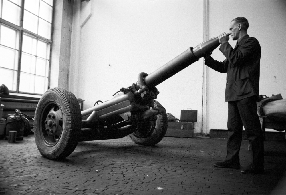 Vanhassa mustavalkoisessa kuvassa mies lataa kranaatinheitintä.