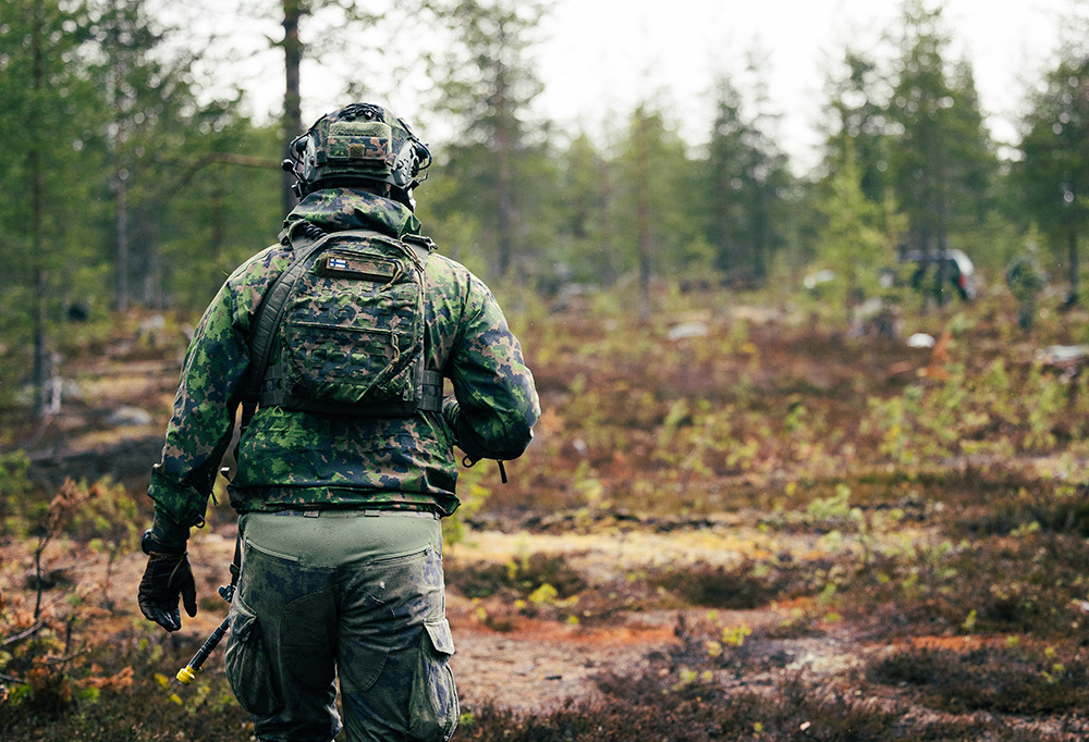 Sotilas kävelee metsässä.
