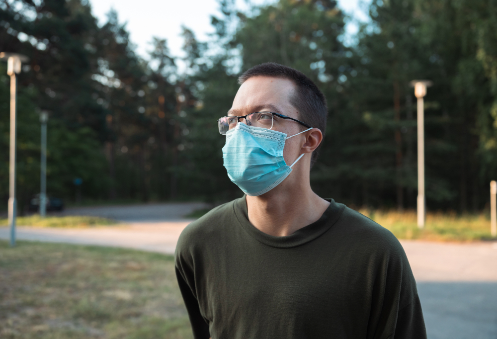 alokas seisoo ulkona maski naamalla.