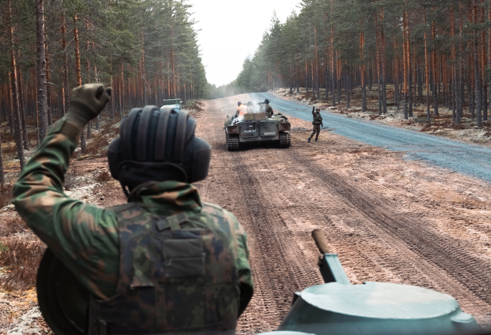 Kuvassa näkyy panssarivaunuja ja kuljettajia vaunujen päällä.