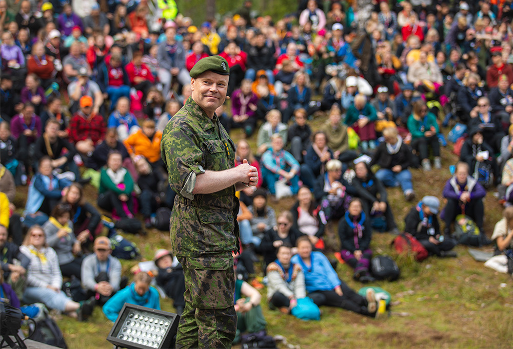 Kuvassa reserviupseerikoulun johtaja, eversti Mikael Salo kertoo johtamisesta yli kolmelletuhannelle partiolaiselle Evon leirintäalueen esiintymislavalla.