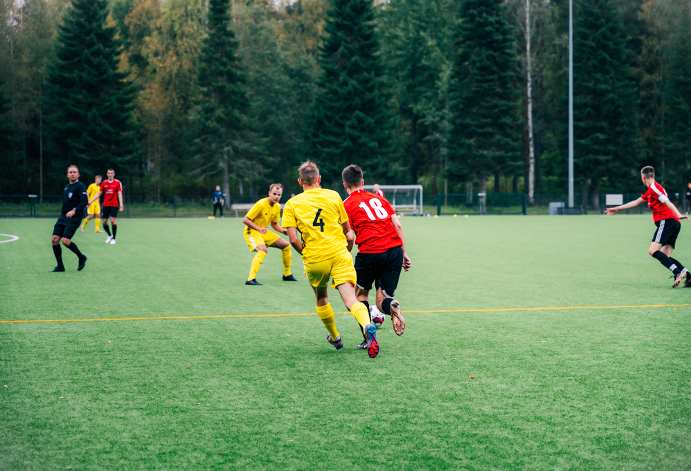 Kuvassa Porin ja Karjalan prikaatien pelaajat pelaavat jalkapalloa Menkalan kentällä.