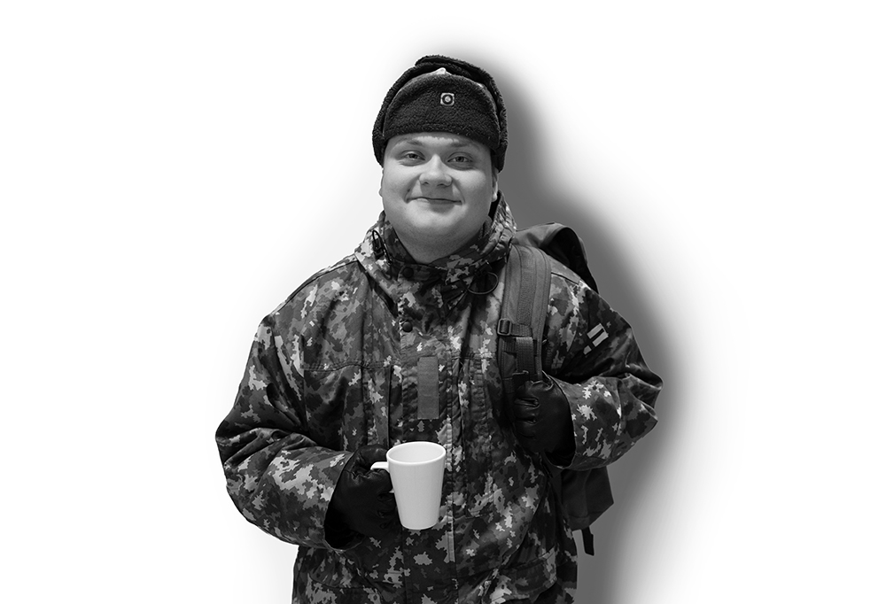 Kaartinjääkäri Eino Nevalainen reppu selässään ja kahvikuppi kädessään.