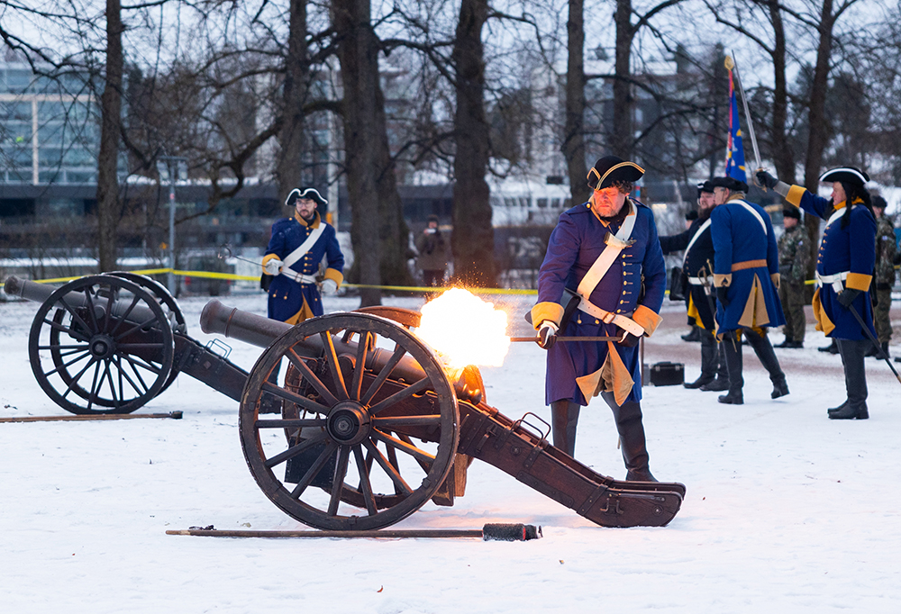 Entisaikojen sotilaan asuun pukeutunut henkilö ampuu tykillä Turun linnan edustalla.