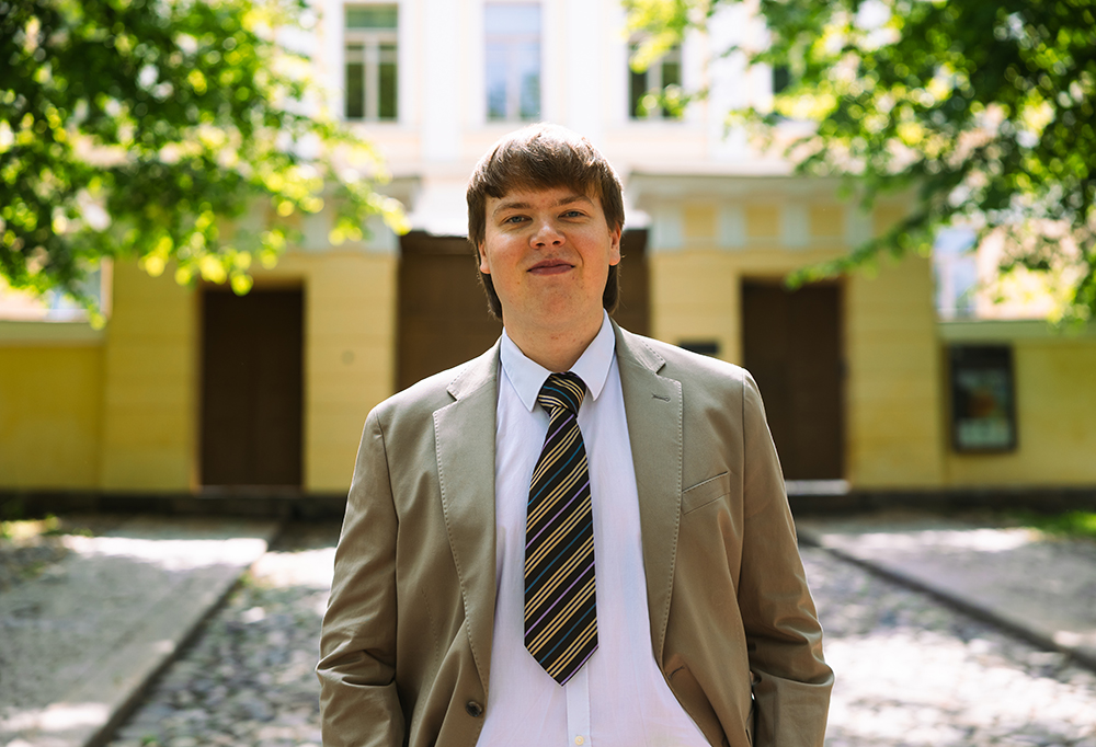 Johannes Koivisto seisoo ulkona ja katsoo hymyillen kohti kameraa.