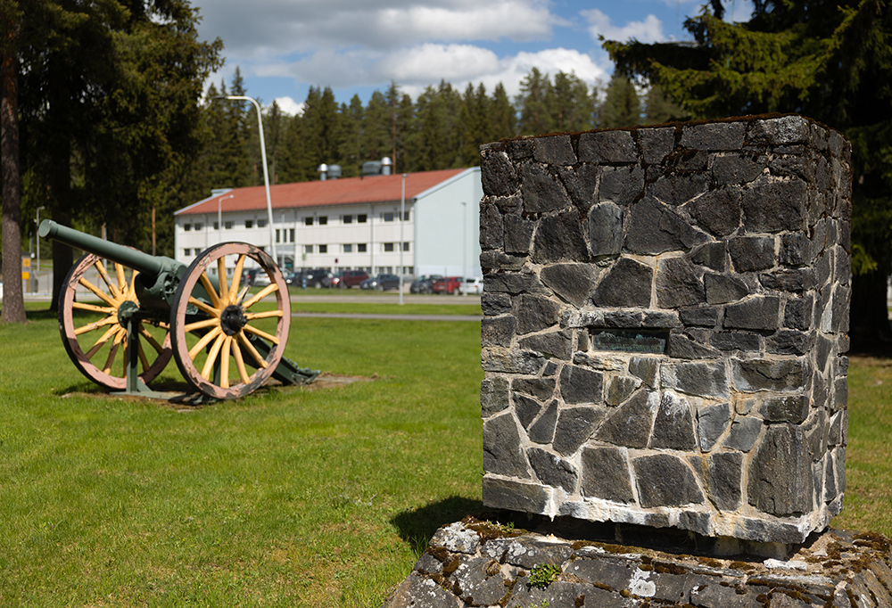 Kuvan etualalla on tykki ja muistomerkki. Taustalla näkyy Maavoimien esikunta-aluetta.
