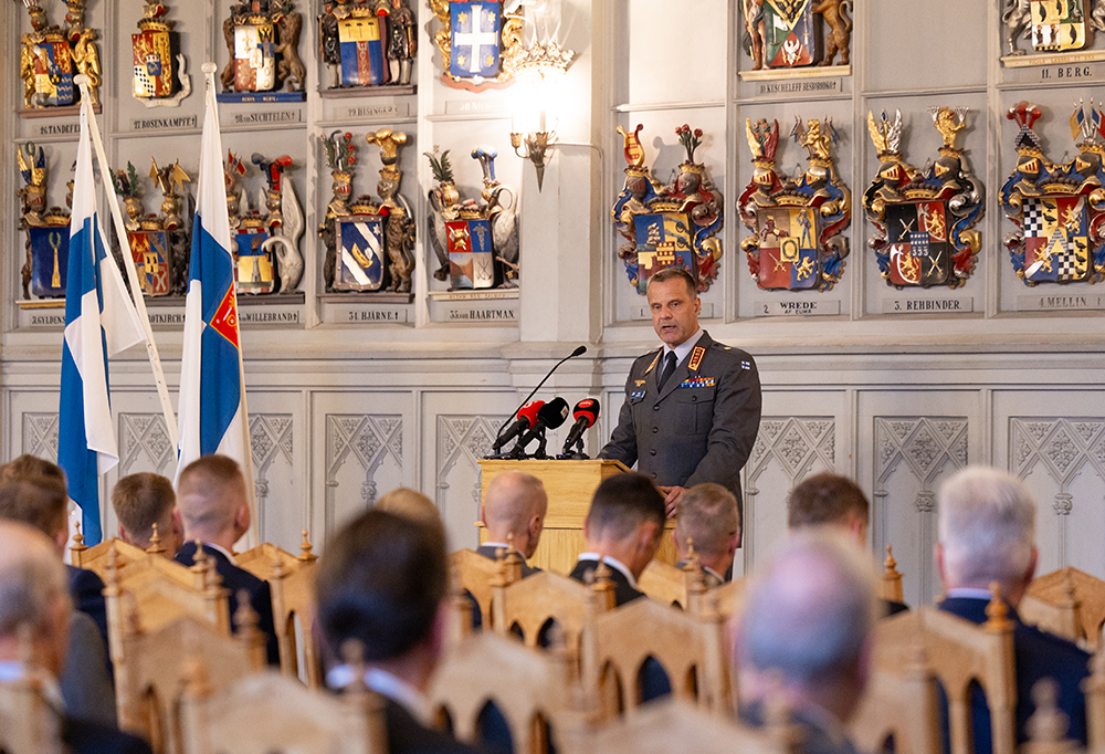 Puolustusvoimain komentaja Janne Jaakkola puhuu yleisön edessä yksityiskohtaisessa salissa.