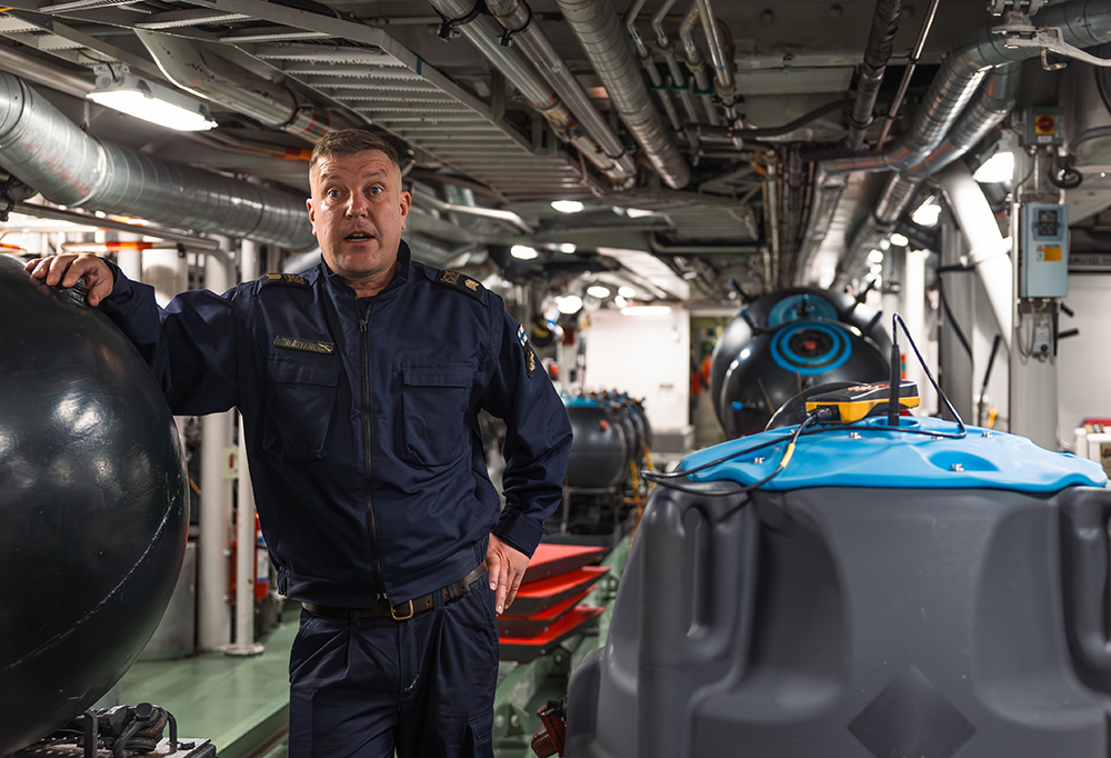 Pursimies Rautanen laivan konehuoneessa. PM16-merimiina kuvan oikeassa reunassa.