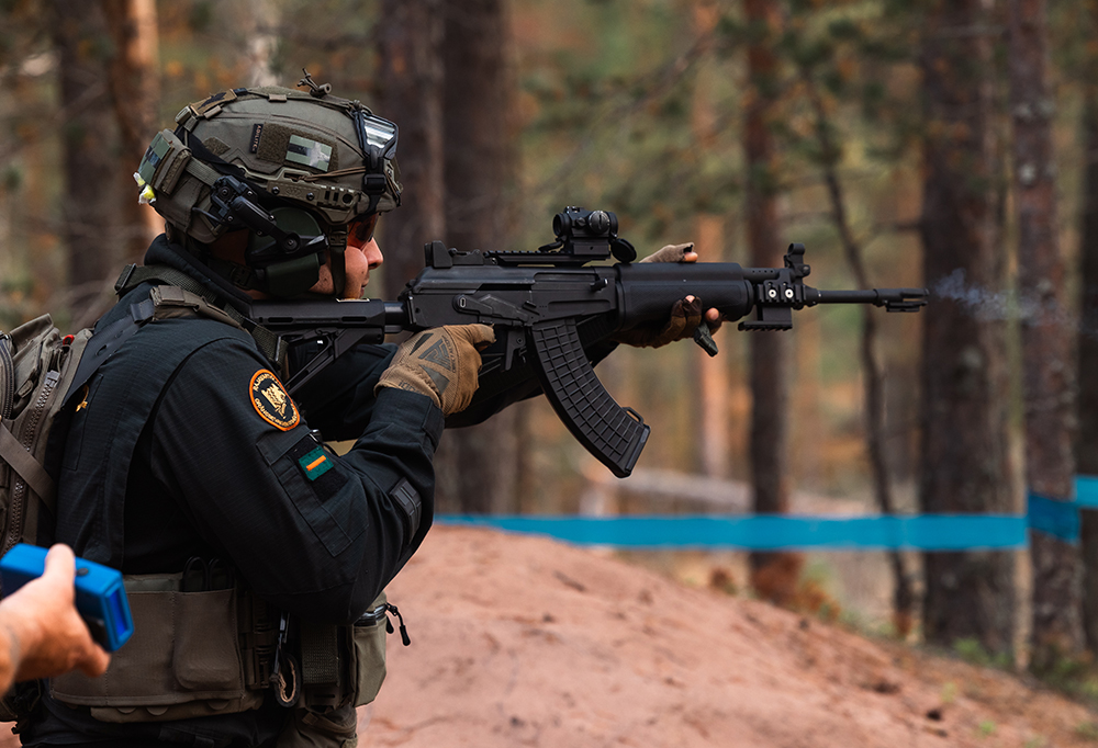 Taistelija on juuri ampunut rynnäkkökiväärillä kangasmetsässä.