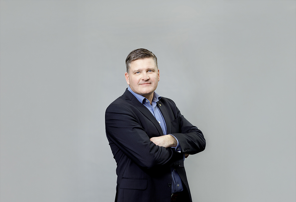 Tero Kivimäki seisoo kädet puuskassa ja katsoo kameraan.