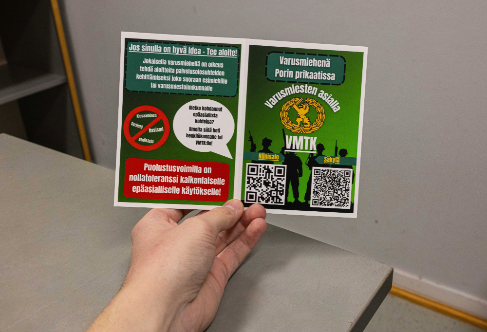Taskukortti QR-koodeineen henkilön kädessä.