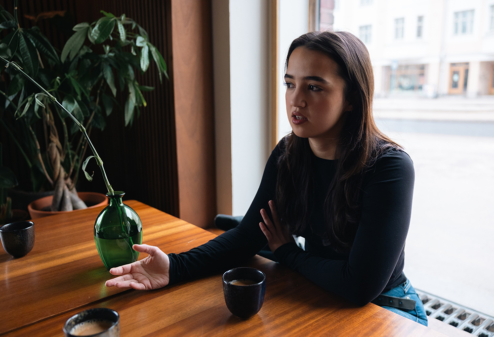 Yasmin Najjar istuu pöydän ääressä kahvikuppi edessään.