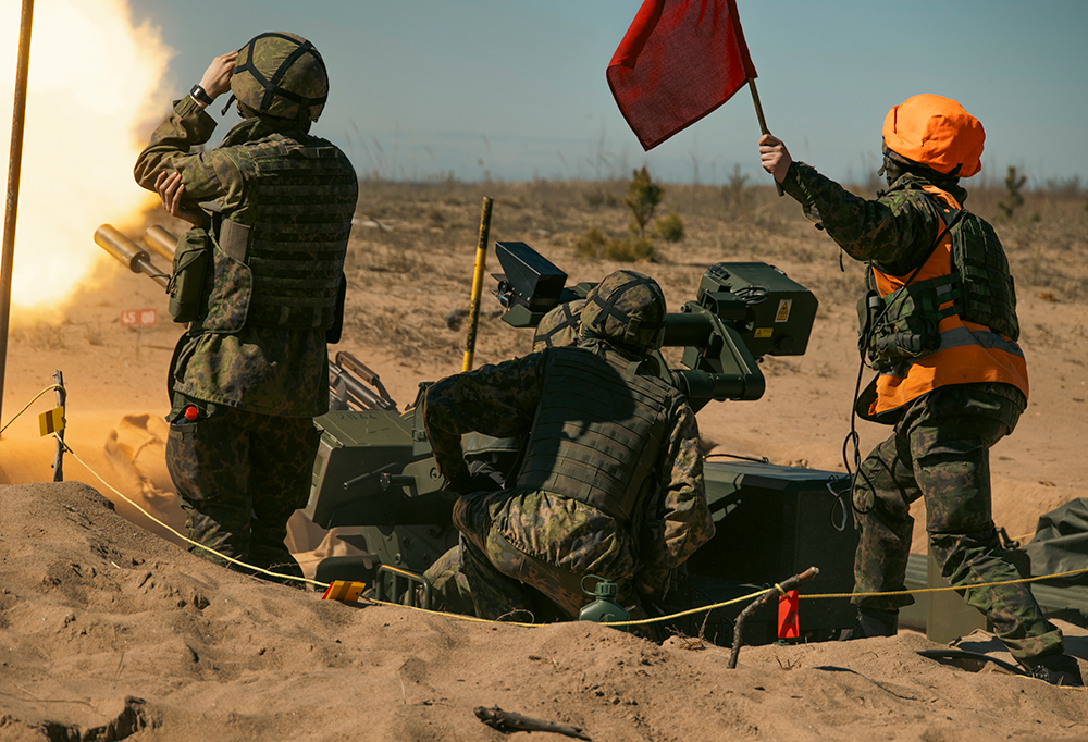 Kolme sotilasta ampumassa ilmatorjuntatykillä
