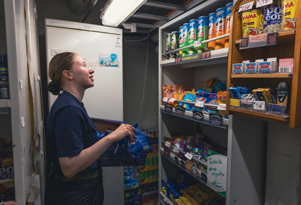 Ylimatruusi Veera Ikävalko hylyttämässä karkkipusseja kanttiinin hyllyyn.