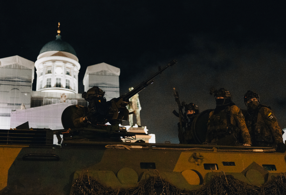 Neljä taistelijaa tähystää panssariajoneuvosta. Taustalla Helsingin tuomikirkon julkisivu.