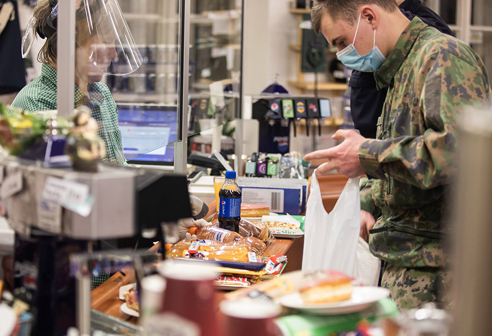 Kuvassa varusmies sotilaskodin kassalla.