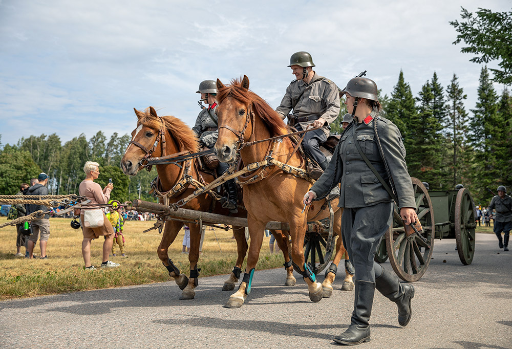Kuvassa kaksi henkilöä vanhoissa sotilaspuvuissa ratsailla.