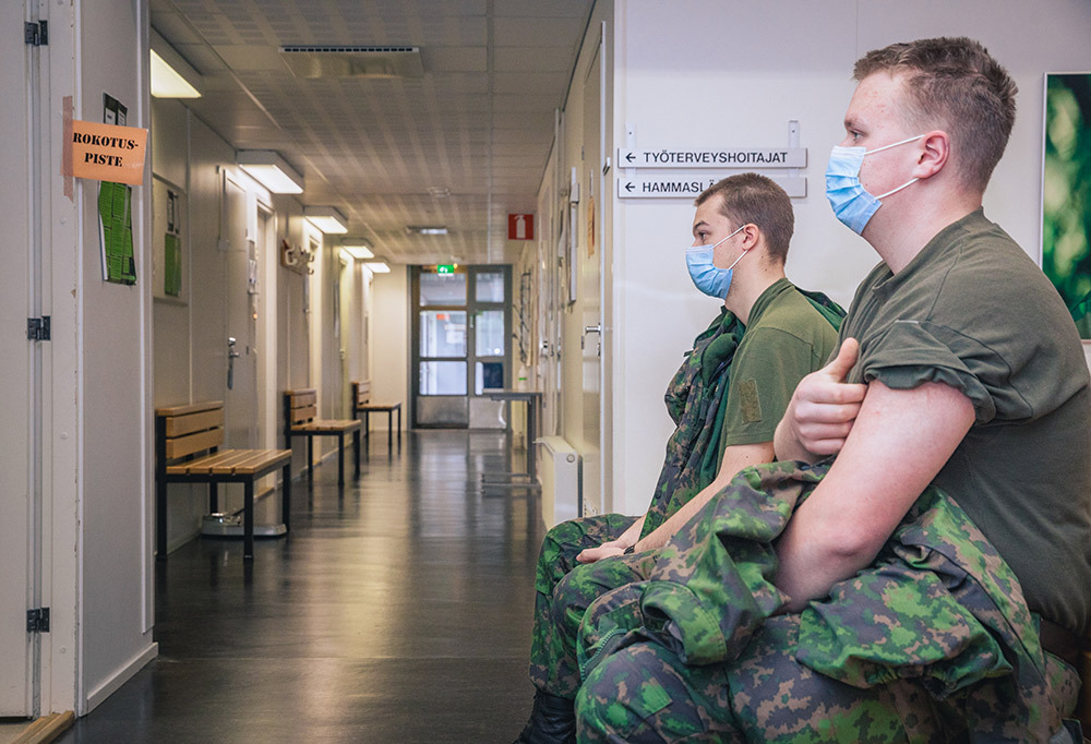 Kuvassa varusmiehiä varuskunnan terveysasemalla menossa koronarokotukseen.