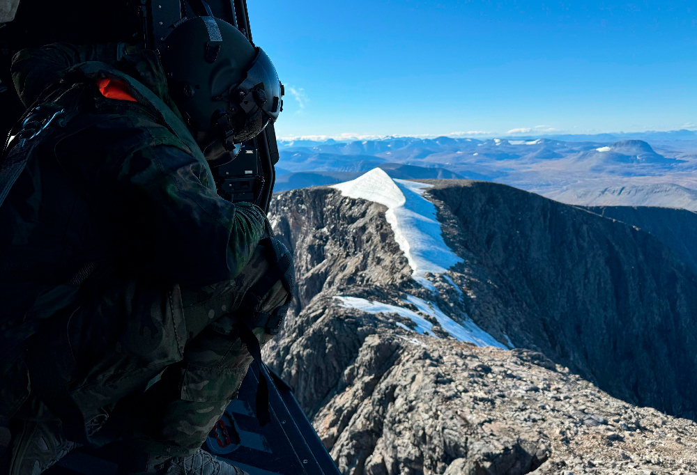 Mies katsoo ulos helikopterista.