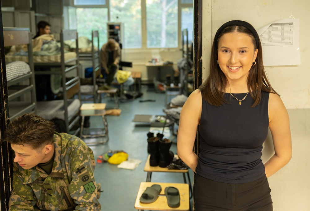 Nainen seisoo oven vieressä.